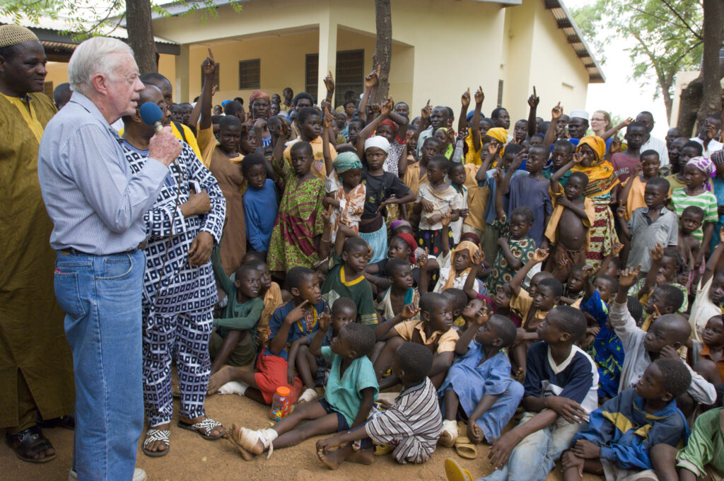 resident Jimmy Carter and his wife Rosalynn address Savelugu children on the seriousness of eradicating guinea worm disease.