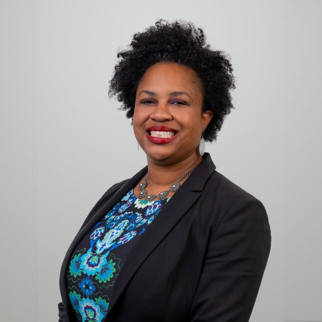 Namandjé N. Bumpus smiles in front of a gray background — politics coverage from STAT