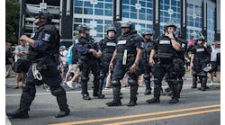 Police in riot gear walk outside Bank of America Stadium before an NFL football game between the Charlotte Panthers and the Minnesota Vikings Sept 25 in Charlotte NC