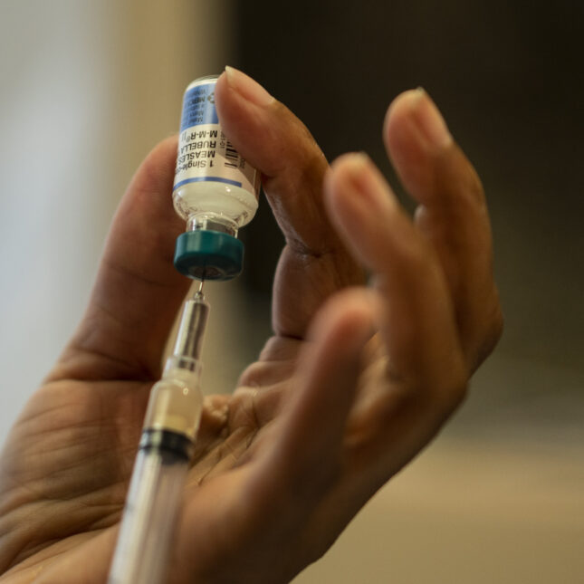 Close up of a nurse preparing an MMR (measles, mumps and rubella) vaccine in a syringe.