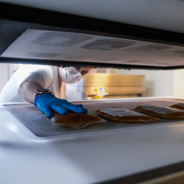 A medical worker places a bag of plasma in a freezer next to four other bags -- first opinion coverage from STAT