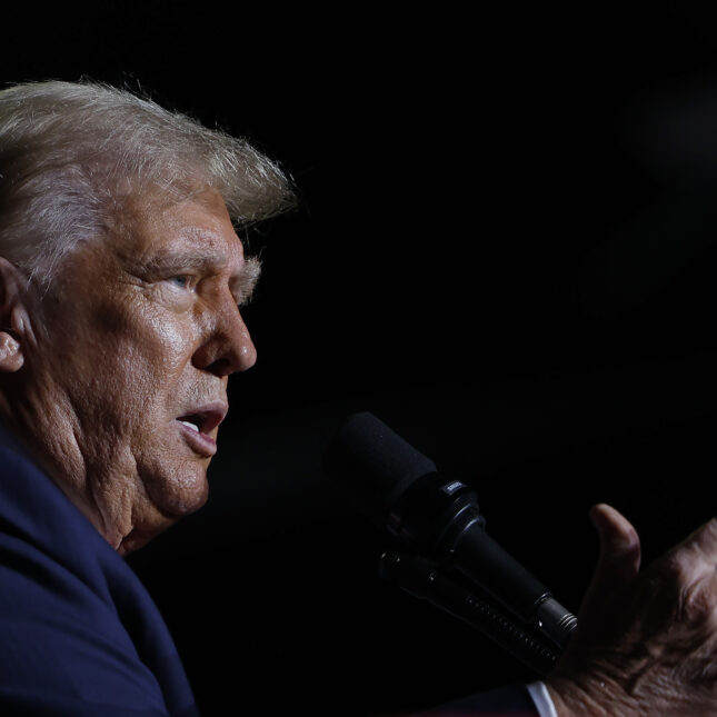 Side profile of Donald Trump speaking at a campaign rally against a dark background. -- health policy coverage from STAT